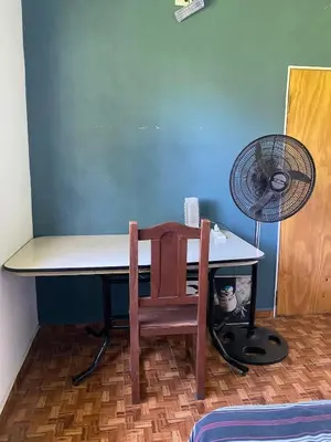 a table with a chair and a fan next to a room at Short-Term Rental in Bialet Massé