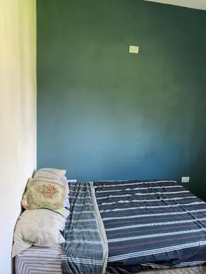 a bed in a bedroom with a blue wall at Short-Term Rental in Bialet Massé