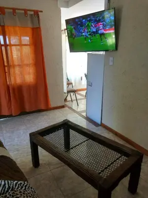 a living room with a tv and a coffee table at Tierra Nuestra in Villa Ciudad de America