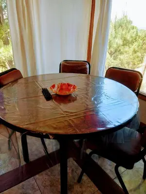 a wooden table with chairs around it with a flower on it at Tierra Nuestra in Villa Ciudad de America