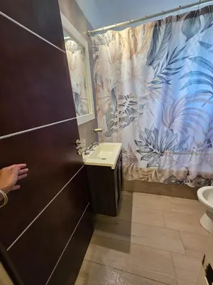 a bathroom with a sink and a toilet and a door at Hermosa casa en Anisacate in Villa Anizacate