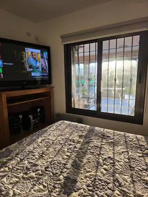 a bedroom with a bed and a flat screen tv at Hermosa casa en Anisacate in Villa Anizacate