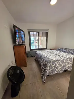 a bedroom with a bed and a flat screen tv at Hermosa casa en Anisacate in Villa Anizacate