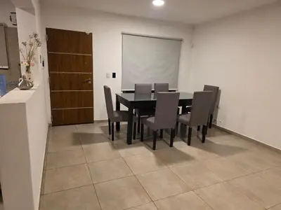 a dining room with a black table and chairs at Hermosa casa en Anisacate in Villa Anizacate