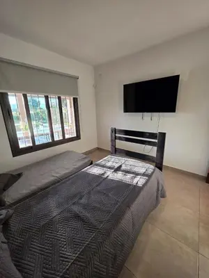 a bedroom with a bed and a flat screen tv at Hermosa casa en Anisacate in Villa Anizacate
