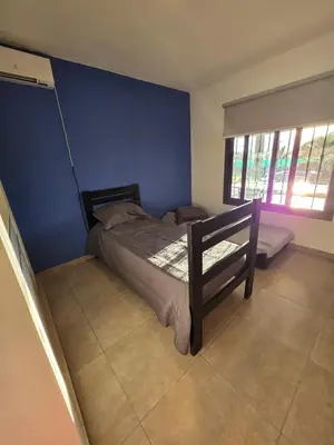 a bedroom with a bed with a blue wall at Hermosa casa en Anisacate in Villa Anizacate