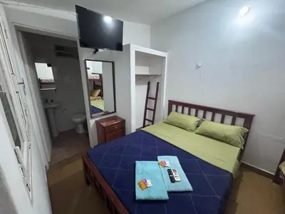 a bedroom with a bed with a blue blanket and a mirror at Colonia 25 de Mayo in Villa Carlos Paz