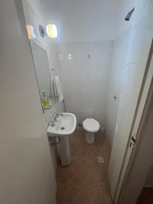 a white bathroom with a sink and a toilet at Colonia 25 de Mayo in Villa Carlos Paz