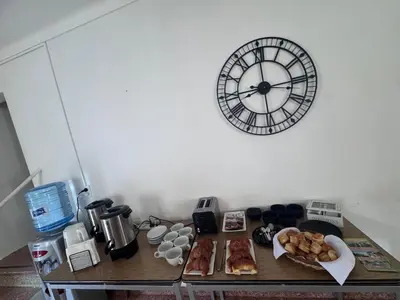 a table with food and a clock on a wall at Colonia 25 de Mayo in Villa Carlos Paz