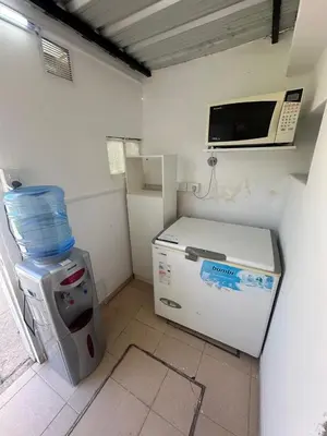 a small kitchen with a microwave and a refrigerator at Colonia 25 de Mayo in Villa Carlos Paz