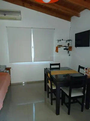 a living room with a table and chairs and a tv at La casita de Otto in Santa María
