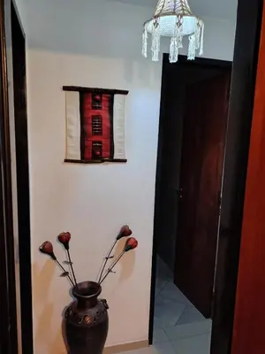a vase with flowers in a room with a window at La casita de Otto in Santa María