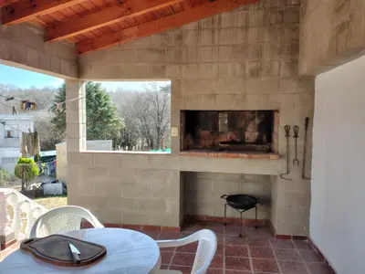 a patio with a fireplace and a table and chairs at La casita de Otto in Santa María