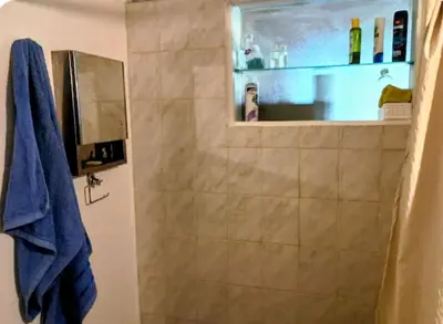 a bathroom with a shower with a blue towel at La casa de Ale in Cordoba