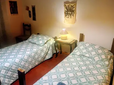 a bedroom with two beds and a table with a lamp at La casa de Ale in Cordoba