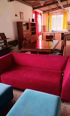 a living room with a red couch and a table at Colorido departamento planta alta in Río Tercero