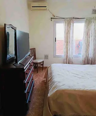 a bedroom with a bed and a flat screen tv at Colorido departamento planta alta in Río Tercero