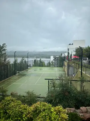 a tennis court next to a body of water at Veneto Village Dpto T3 1 K in Villa Parque Siquiman