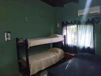 two bunk beds in a green room with a window at Dptos victoria in Mina Clavero