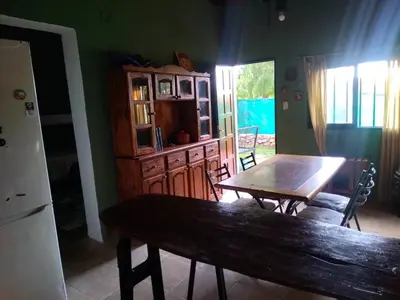 a dining room with a wooden table and a wooden cabinet at Dptos victoria in Mina Clavero