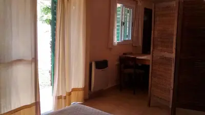 a bedroom with a bed and a desk and a window at Casita del Lago in Villa Carlos Paz