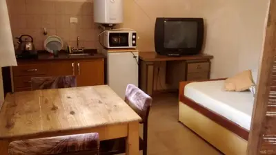 a small kitchen with a small table and a refrigerator at Casita del Lago in Villa Carlos Paz