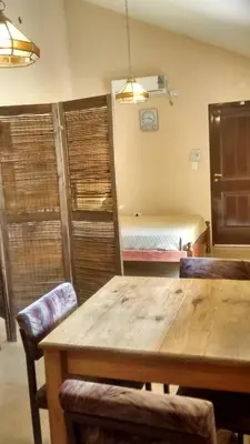 a room with a wooden table and a bed at Casita del Lago in Villa Carlos Paz