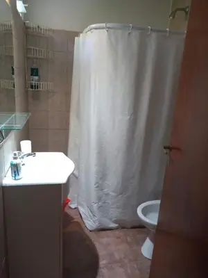 a bathroom with a shower curtain and a toilet at Casita del Lago in Villa Carlos Paz