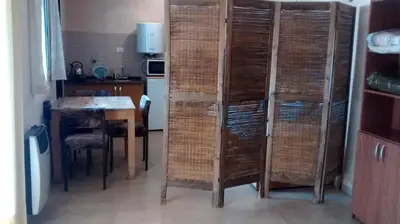 a room with a kitchen with a table and some baskets at Casita del Lago in Villa Carlos Paz
