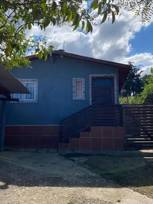 a blue house with stairs and a door at Departamento El Delfín in Tanti
