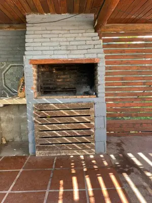 an outdoor brick oven with a wooden roof at Departamento El Delfín in Tanti