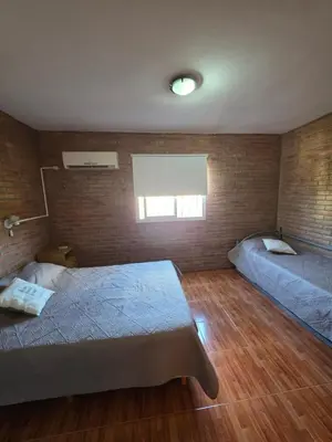 a bedroom with two beds and a brick wall at Complejo de departamentos 7 Cielos in Villa Carlos Paz