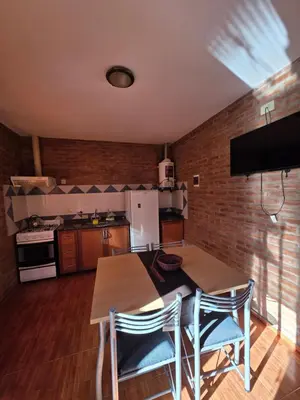 a kitchen with a wooden table and two chairs at Complejo de departamentos 7 Cielos in Villa Carlos Paz