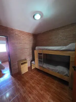 a bedroom with a bunk bed and a brick wall at Complejo de departamentos 7 Cielos in Villa Carlos Paz