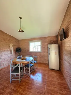 a dining room with a table and a refrigerator at Complejo de departamentos 7 Cielos in Villa Carlos Paz
