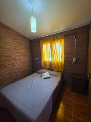 a bedroom with a bed with a yellow curtain at Complejo de departamentos 7 Cielos in Villa Carlos Paz