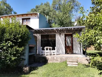 a small blue and white house with a table on the porch at Casita Santa Elena N3 in Trapiche