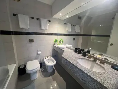 a bathroom with two sinks and a toilet and a mirror at VILAUT Great studio, strategic location with Pool, Gym and Coworking area in Cordoba