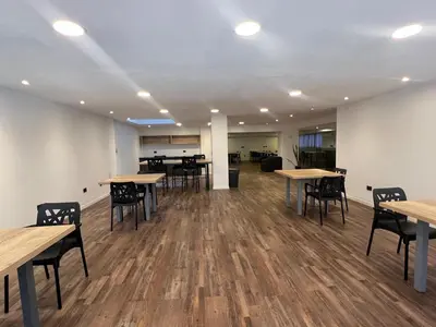 an empty room with wooden tables and chairs at VILAUT Great studio, strategic location with Pool, Gym and Coworking area in Cordoba