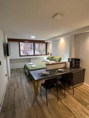 a living room with a table and a couch at VILAUT Great studio, strategic location with Pool, Gym and Coworking area in Cordoba