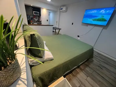 a room with a bed and a flat screen tv at VILAUT Great studio, strategic location with Pool, Gym and Coworking area in Cordoba
