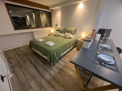 a bedroom with a bed and a desk with a desk at VILAUT Great studio, strategic location with Pool, Gym and Coworking area in Cordoba