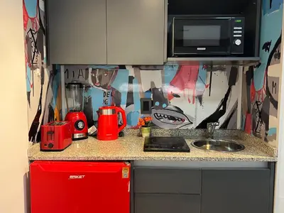 a kitchen counter with a red refrigerator and a microwave at VILAUT Great studio, strategic location with Pool, Gym and Coworking area in Cordoba