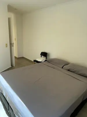 a large white bed in a room with a chair at Departamento Duarte Quiros 274 in Cordoba