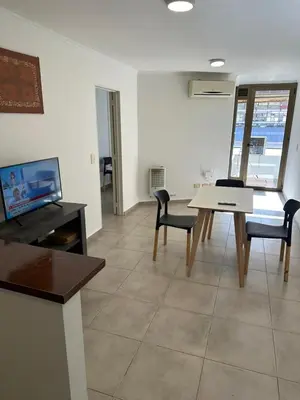 a living room with a table and chairs and a tv at Departamento Duarte Quiros 274 in Cordoba