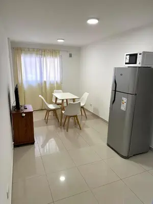 a dining room with a table and a refrigerator at Departamento Barrio General Paz in Cordoba