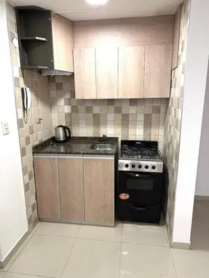 a small kitchen with a stove and cabinets at Departamento Barrio General Paz in Cordoba