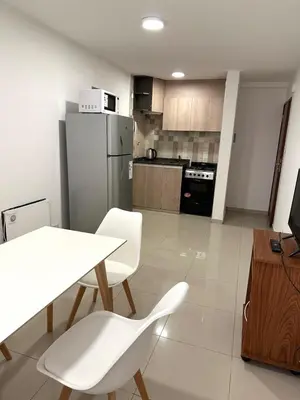 a kitchen with a table and chairs and a refrigerator at Departamento Barrio General Paz in Cordoba
