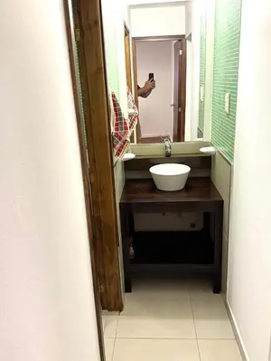 a person taking a picture of a bathroom sink at Departamento Barrio General Paz in Cordoba