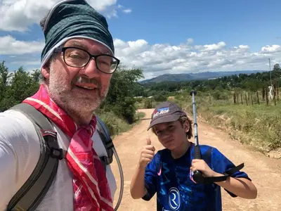 a man and a girl standing on a dirt road at Los árboles in Potrero de Garay